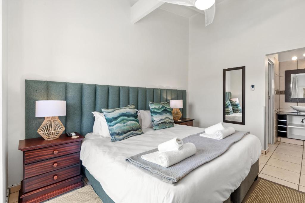 una camera con un grande letto con testiera verde di San Lameer Villa 3122 - 3 Bedroom Classic - 6 pax - San Lameer Rental Agency a Southbroom