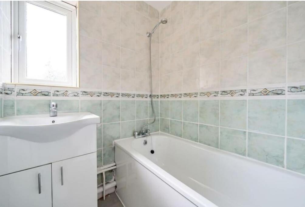 bagno con vasca e lavandino di A Luxurious 3 Bed-Terrance House a Londra