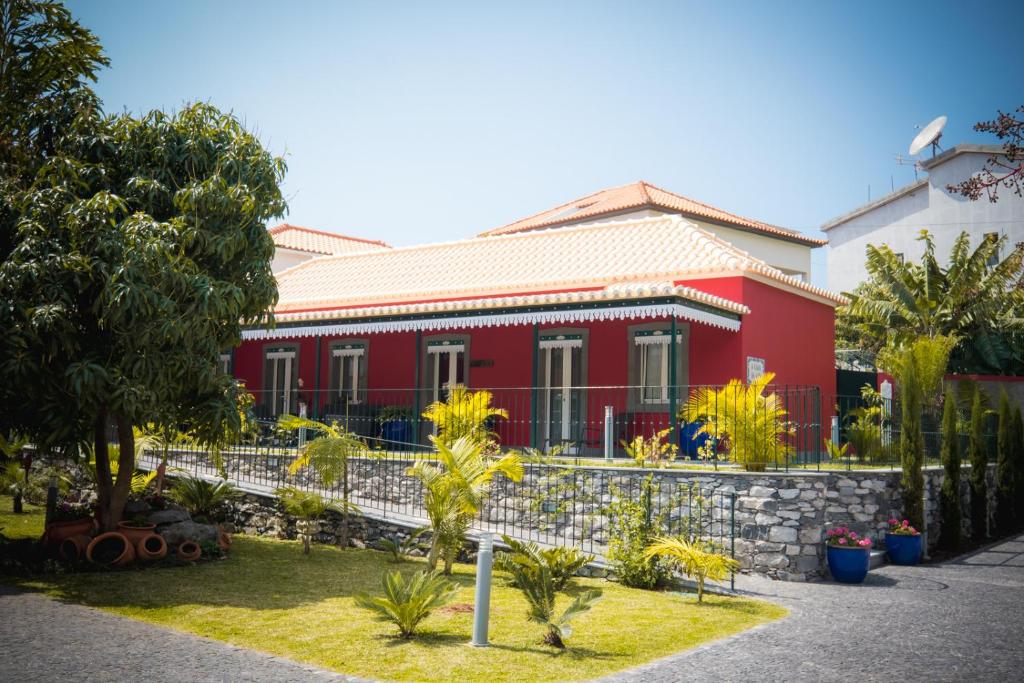 een rood huis met een hek ervoor bij Quinta da Tia Briosa by Madeira Sun Travel in Ponta do Sol