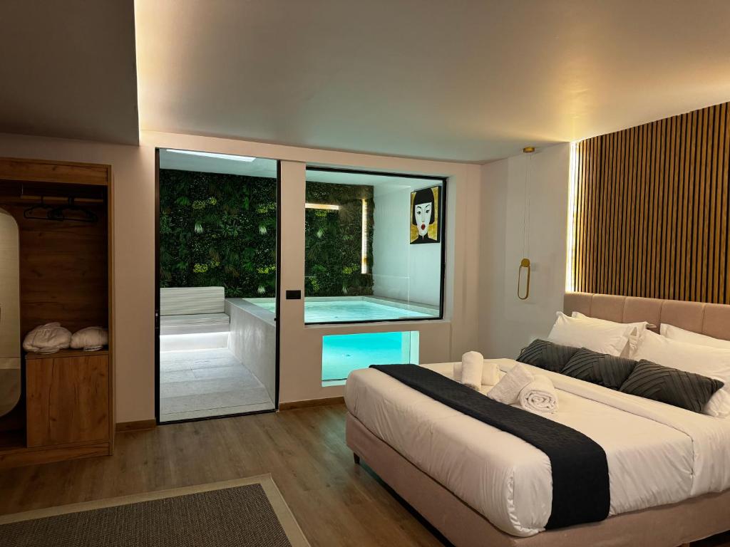 a bedroom with a large bed and a swimming pool at CITYLUXE Suites & Rooms in Athens