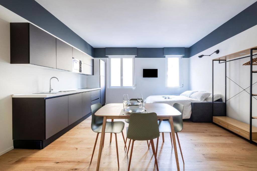 ミラノにあるEasylife - Stupendo Monolocale zona Risorgimentoのキッチン(テーブル、椅子、ベッド付)