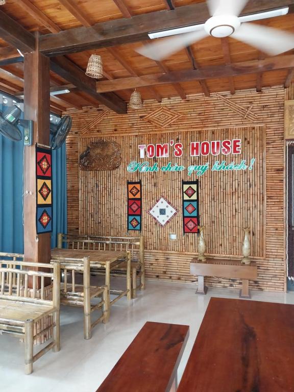ein Zimmer mit Bänken und ein Schild, auf dem steht: in der Unterkunft Tom's House in Hòa Bình