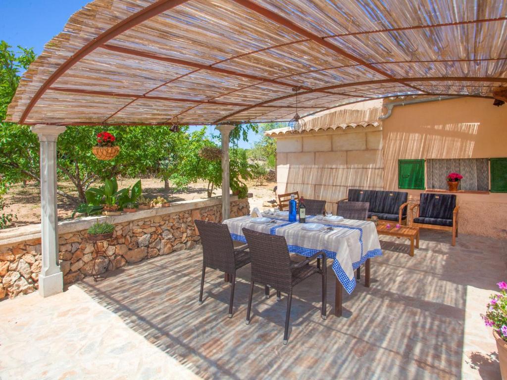 eine Terrasse mit einem Tisch und Stühlen unter einer Pergola in der Unterkunft Barranc De Son FullÓs - Villa With Private Pool In Santa Margalida Free Wifi in Santa Margalida