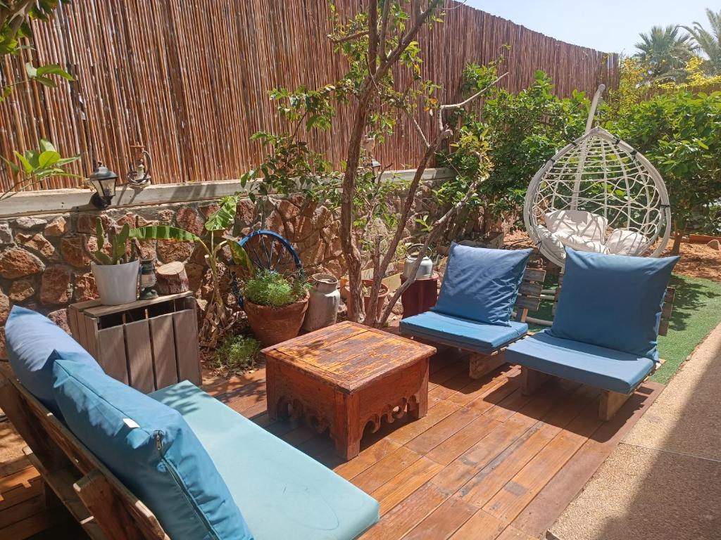 a patio with two blue chairs and a swing at Red Sea Garden Apartment in Eilat