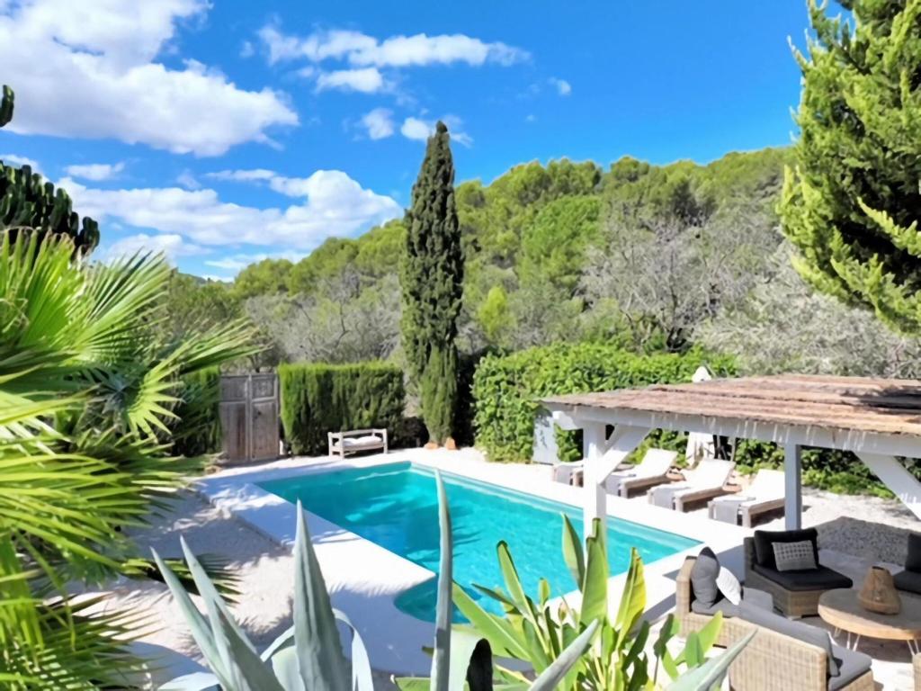 einen Pool in einem Garten mit Stühlen und Bäumen in der Unterkunft Beautiful Villa with Private Pool in Benissa in Benissa