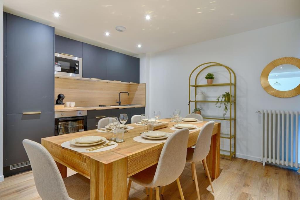 Un comedor con mesa y sillas de madera. en Welcome to Forest House, en Marly-le-Roi