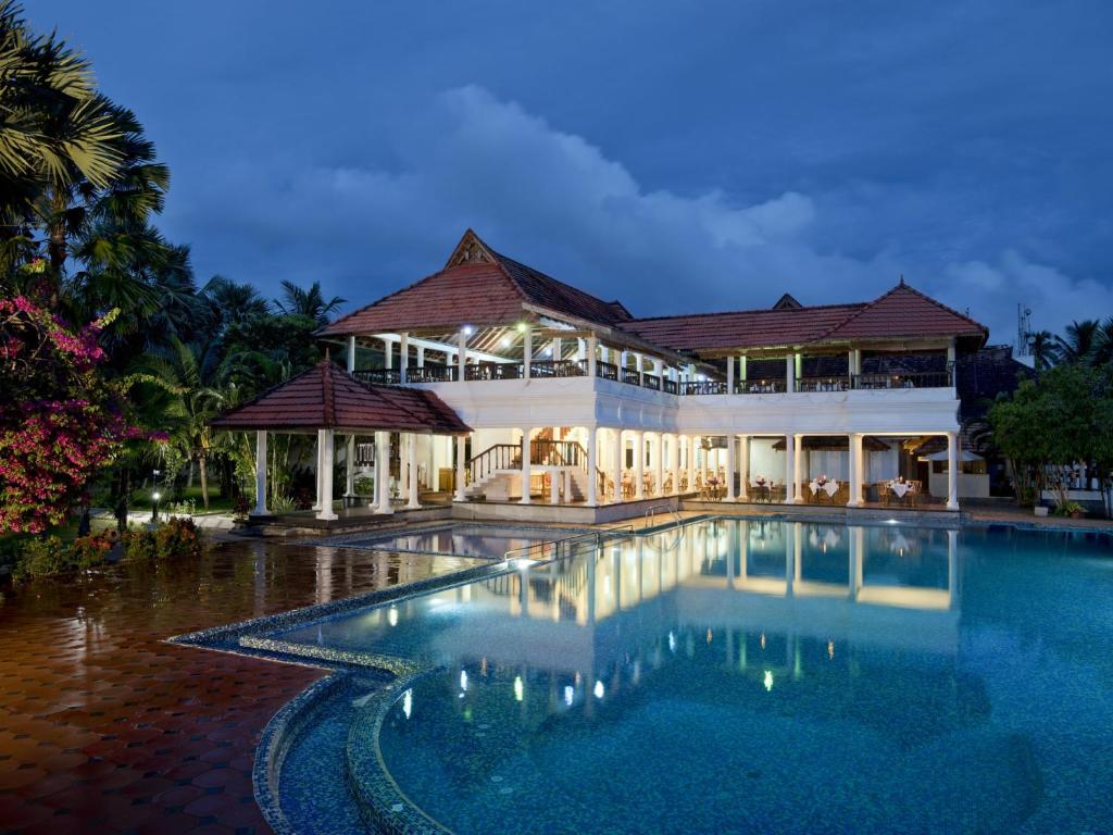 a large swimming pool in front of a building at Isola Di Cocco Ayurvedic Beach Resort in Pūvār