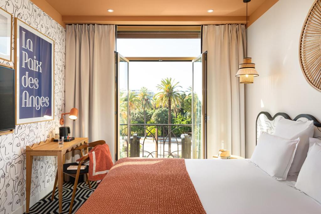 a hotel room with a bed and a balcony at Albert 1er in Nice