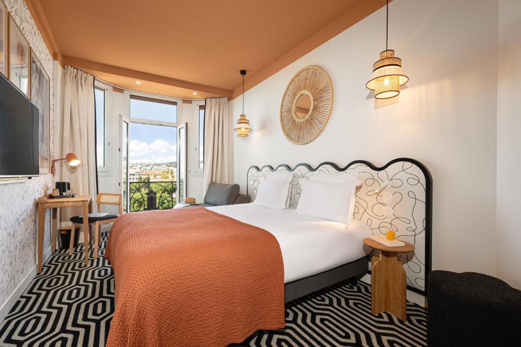 a hotel room with a bed and a balcony at Albert 1er in Nice