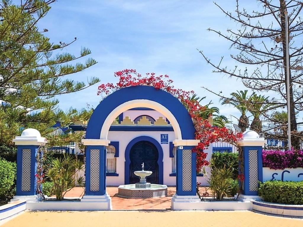 Beautiful holiday home in Roquetas de Mar by the sea في روكويتاس دي مار: مبنى ازرق وابيض وامامه نافورة
