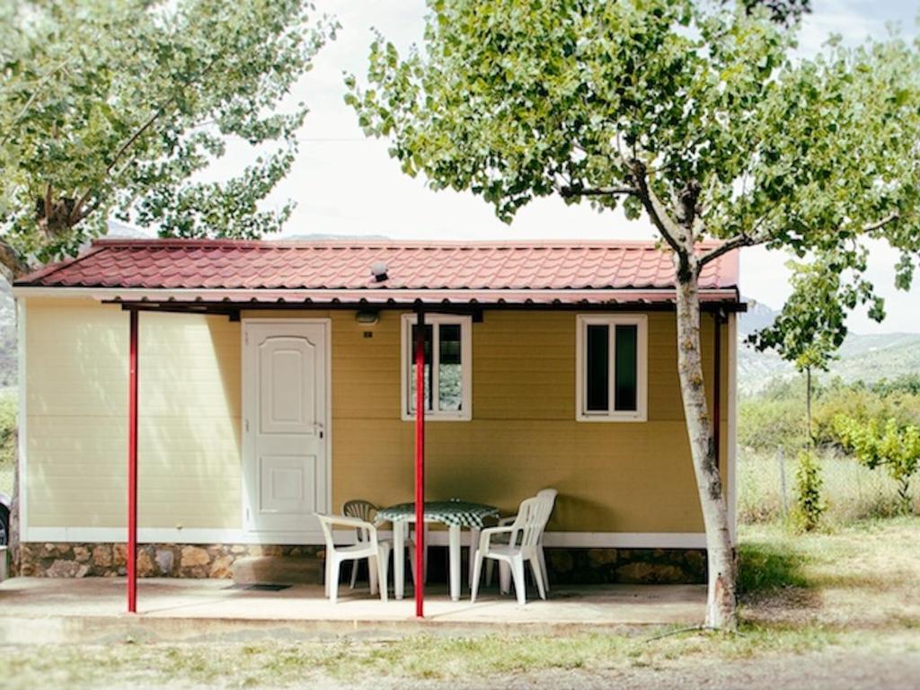 La Puebla de RodaにあるHoliday home Vakantiepark Isábena 4の小さな黄色の家(テーブルと椅子付)