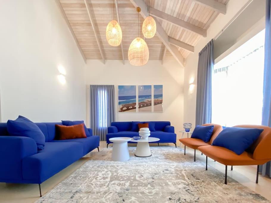 un soggiorno con divani blu e un tappeto di Stylish Villa with Bomb Shelter Close to Shore a Caesarea