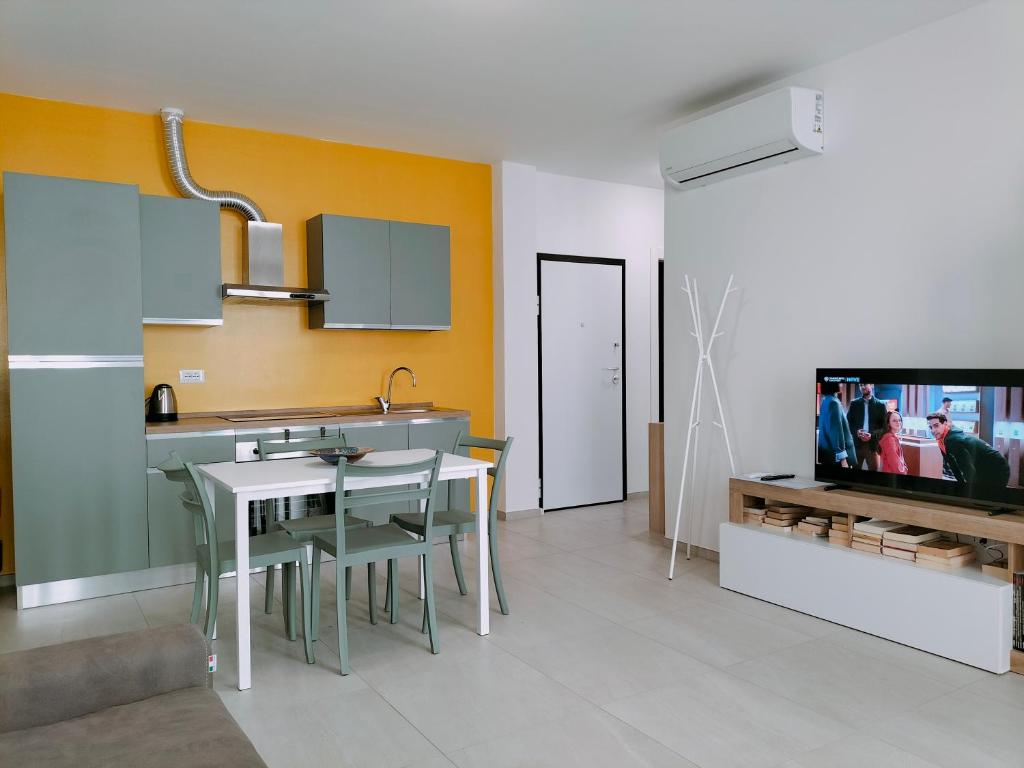 uma cozinha com um lavatório, uma mesa e uma televisão em FaCentro - Pratico flat in centro storico em Faenza