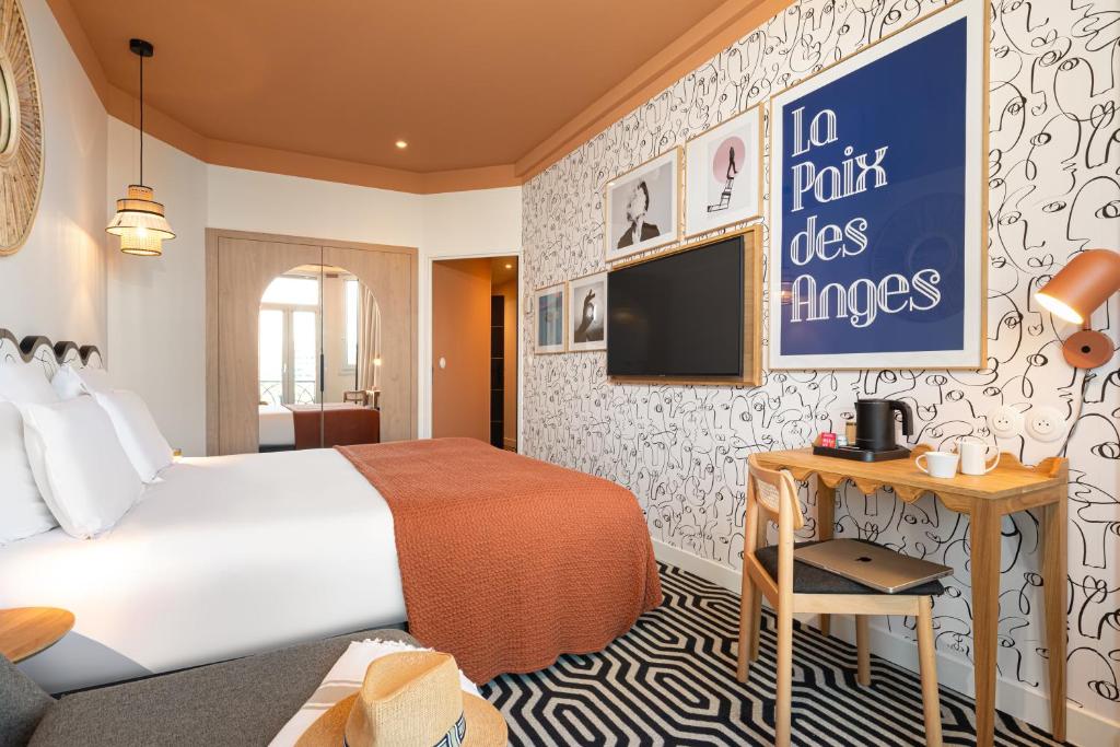 a hotel room with a bed and a flat screen tv at Albert 1er in Nice