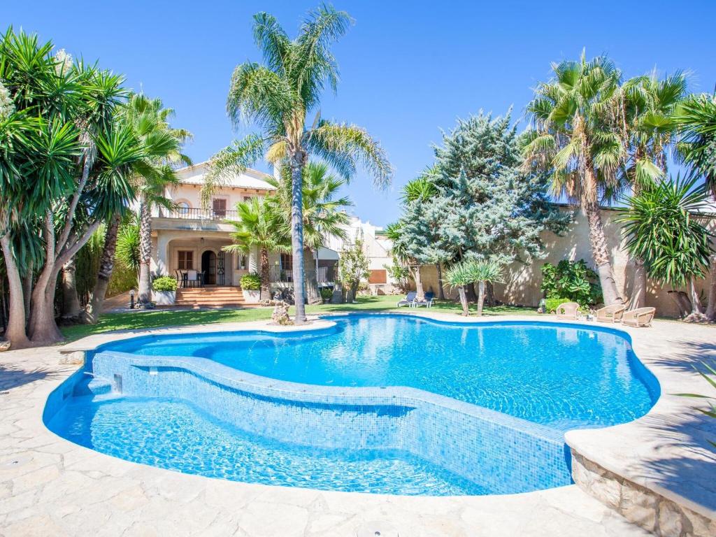 - une piscine en face d'une maison avec des palmiers dans l'établissement Can Gual - Villa With Private Pool In Inca Free Wifi, à Inca