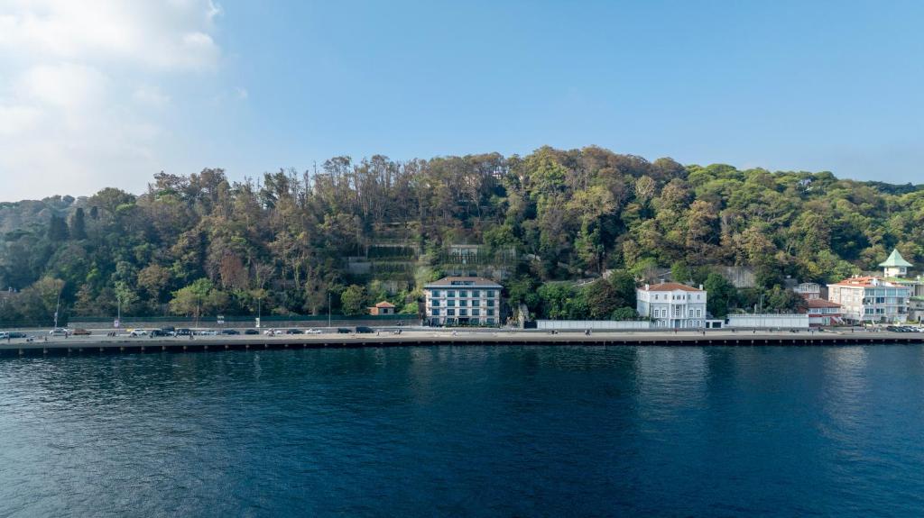 a large body of water with buildings and trees at MFB Tarabya Hotel in Istanbul