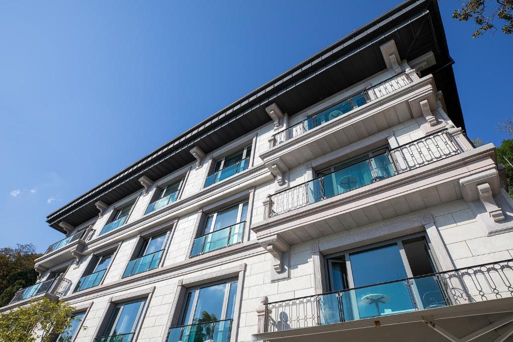 a white building with balconies on a blue sky at MFB Tarabya Hotel in Istanbul