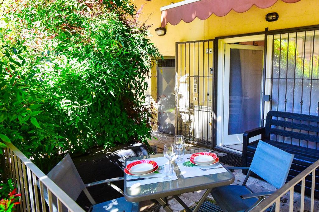 una mesa con platos y copas de vino en un patio en La Casa dei Laghi 1 Comabbio Monate Maggiore Orta, en Mercallo