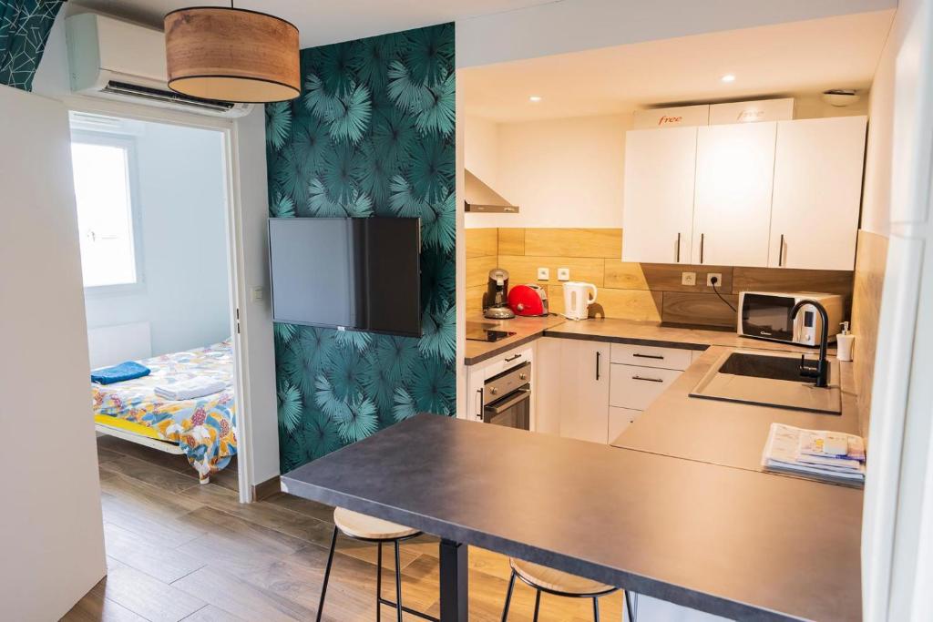 une cuisine avec une table et des chaises dans une pièce dans l'établissement Havre de paix Climatisé Parking T2, à Lourdes