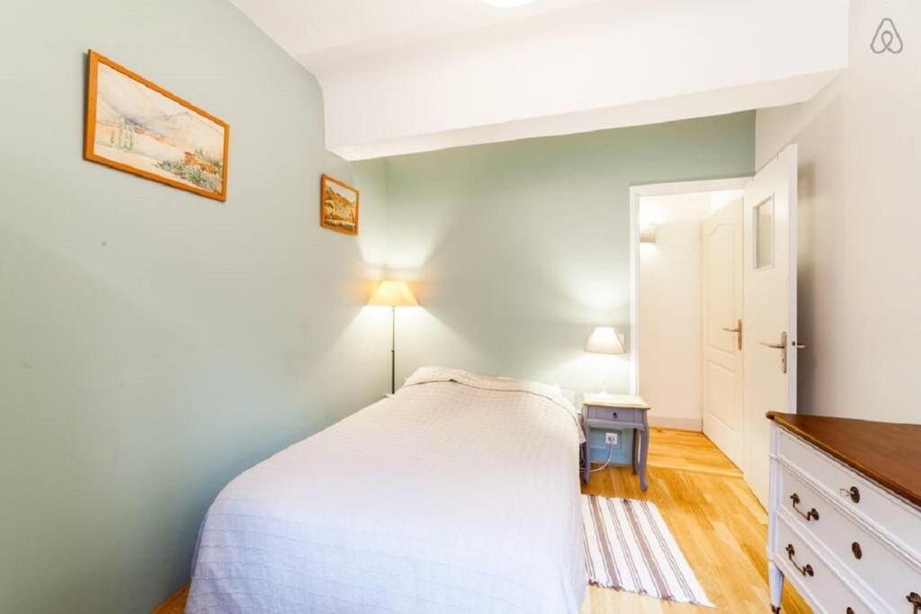 a small bedroom with a white bed and a table at Incredible location - in the heart of old town in Lyon