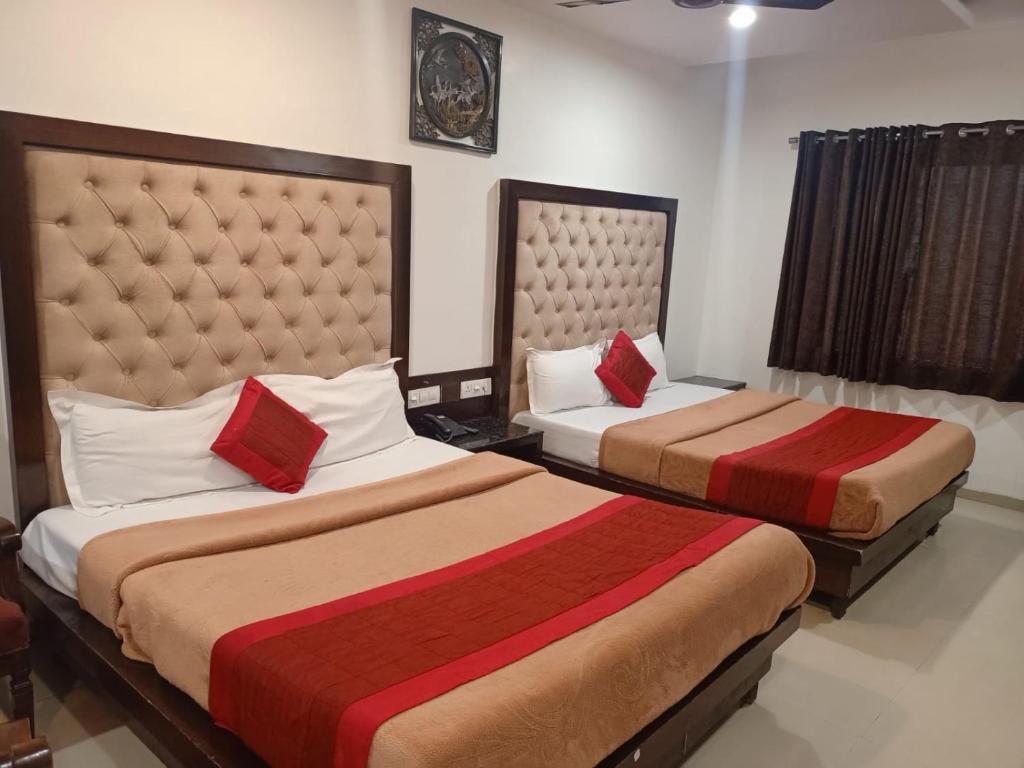 a hotel room with two beds with red pillows at Hotel Mohan Family-Friendly Hotels @ New Delhi Railway Station in New Delhi