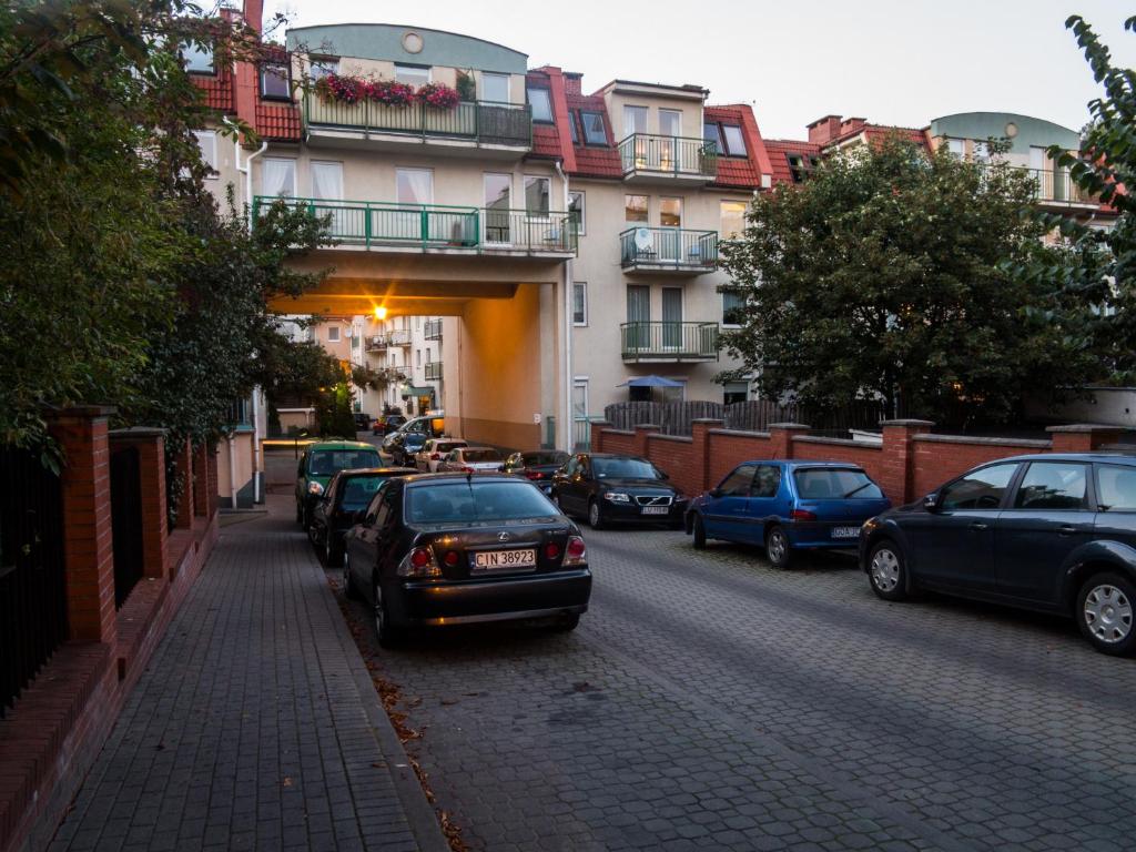 eine Gruppe von Autos, die an der Straßenseite geparkt sind in der Unterkunft Sopot Apartament in Sopot