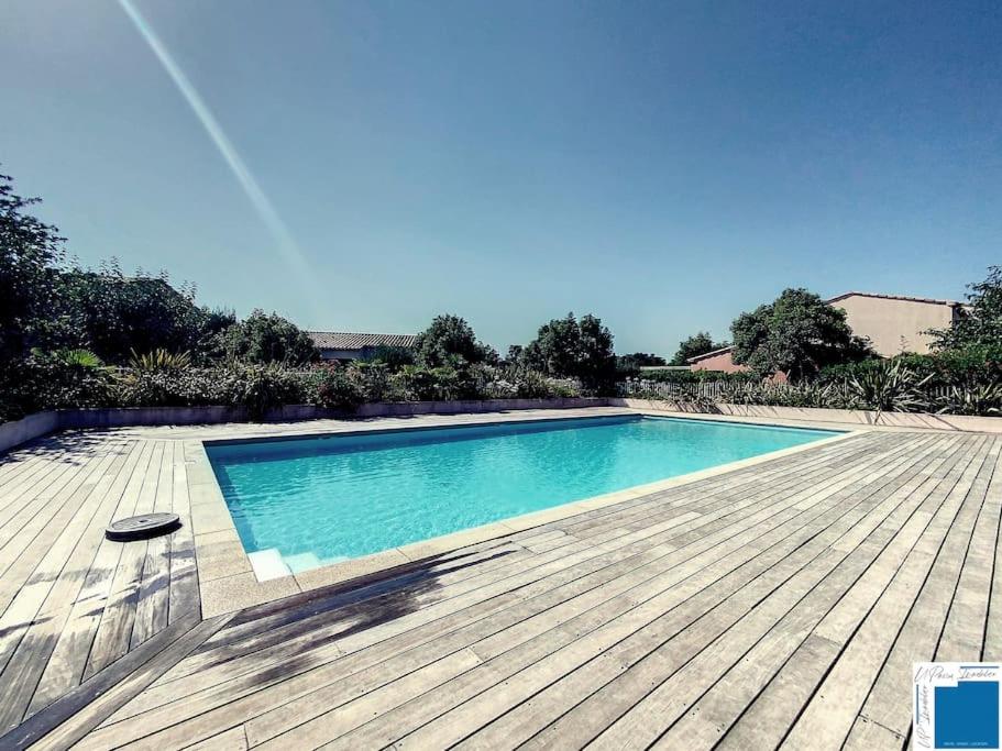 une grande piscine avec une terrasse en bois dans l'établissement Villa Pomelo - Jacuzzi - Piscine- Climatisation, à Lecci