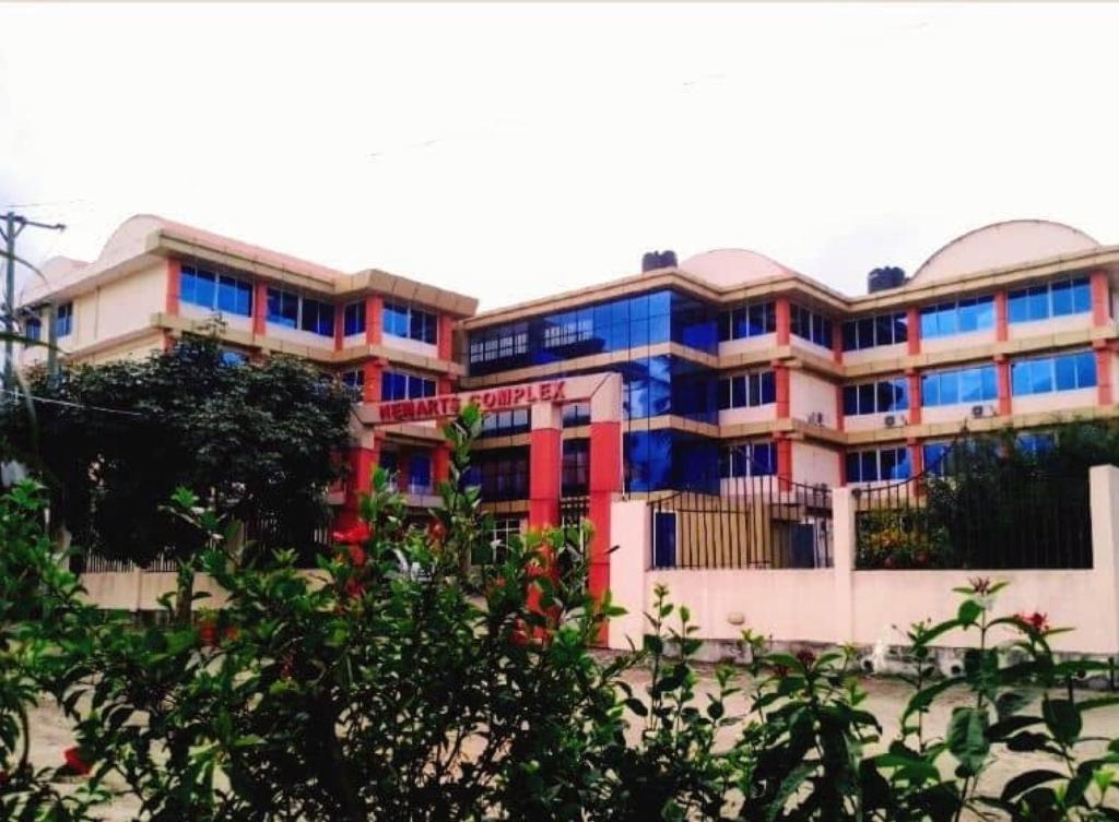 un grand bâtiment avec des fenêtres colorées. dans l'établissement Nemart's Hotel, à Dar es Salaam