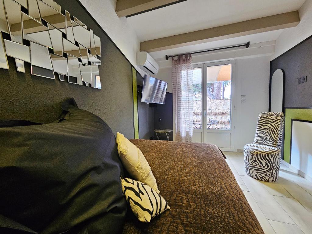 una camera con letto, TV e sedia di Appartement Style Loft - proche Village Naturiste a Cap d'Agde