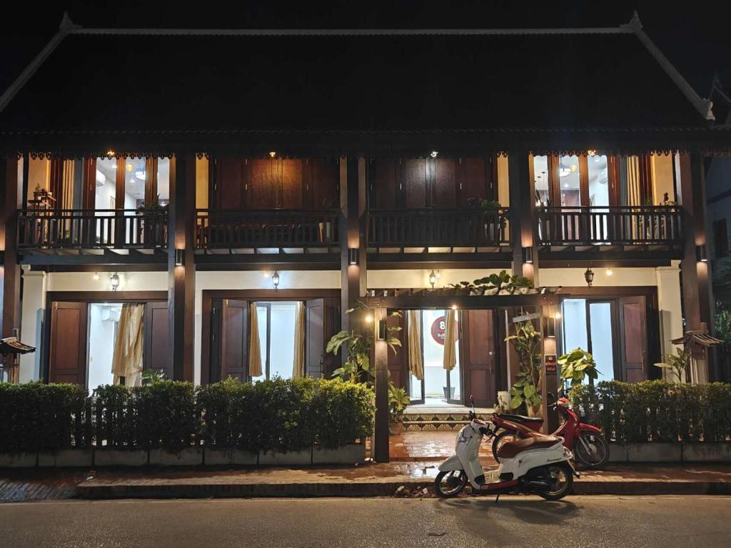 skuter zaparkowany w nocy przed budynkiem w obiekcie Happy hour HOTEL w mieście Luang Prabang