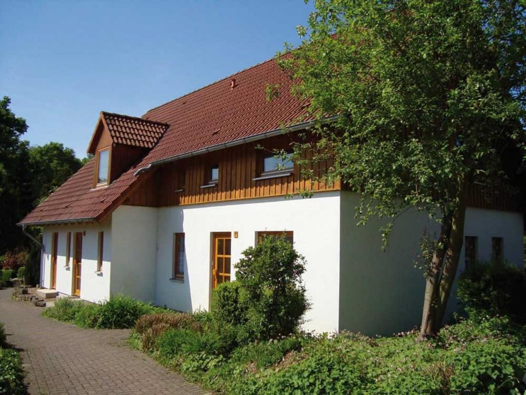 a white house with a brown roof at Comfortable holiday home with 2 bathrooms in the Bruchttal in Bredenborn
