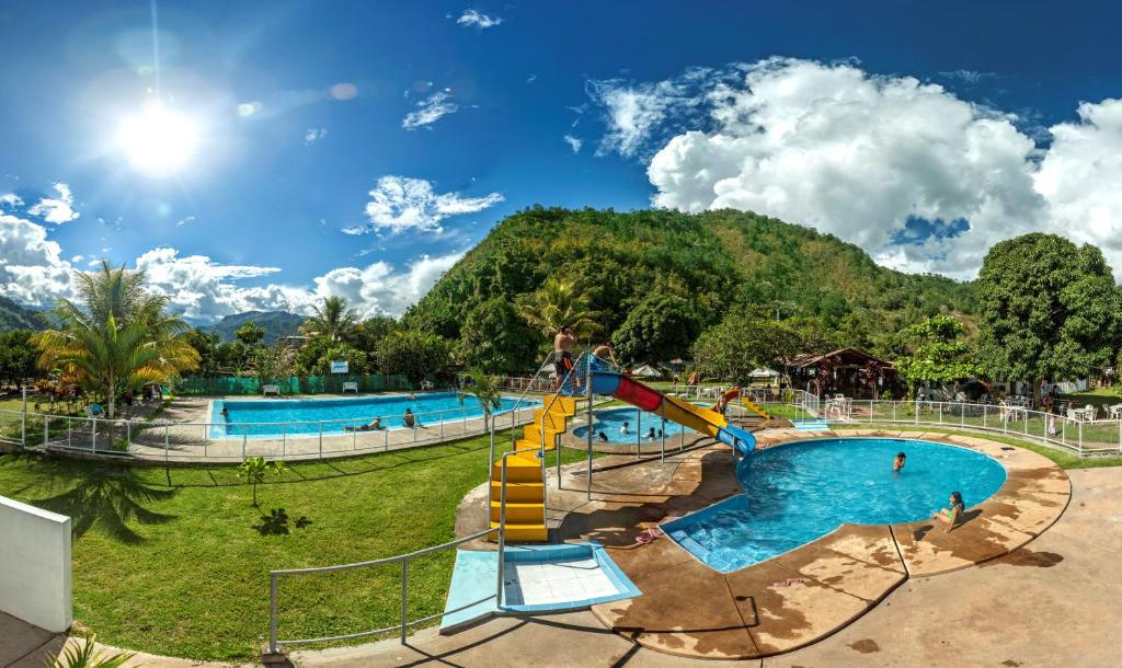 un parque acuático con 2 piscinas y un tobogán en Hotel El Tirol, en San Ramón
