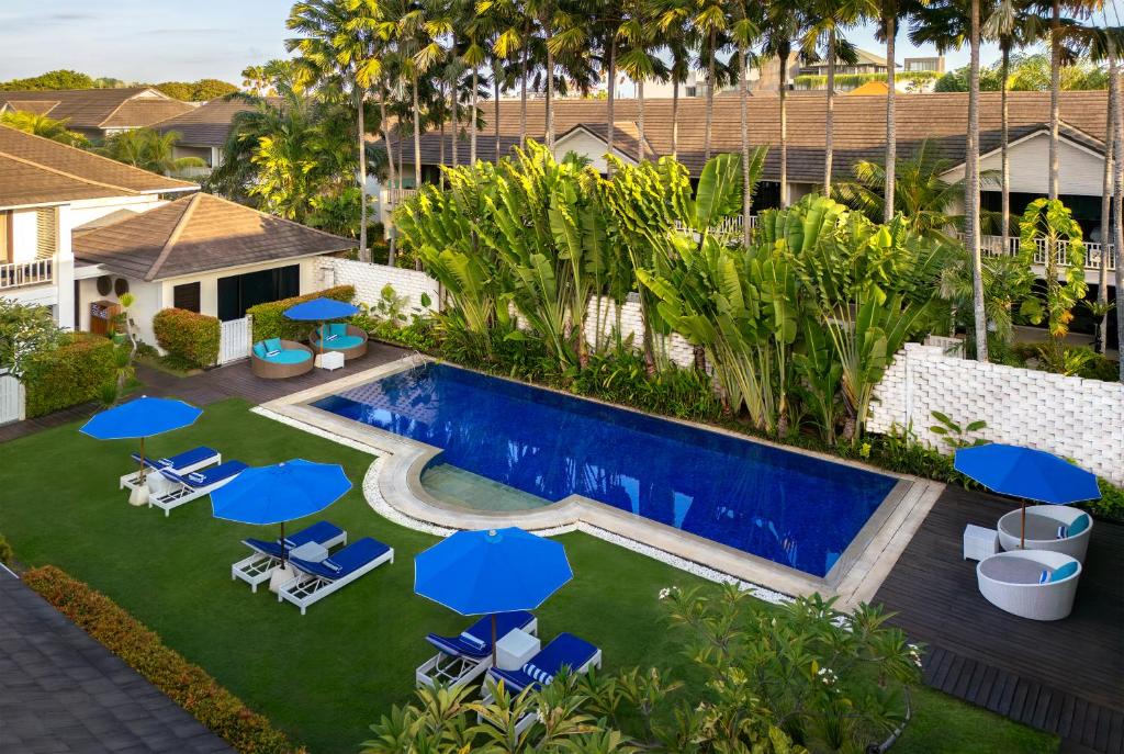 an aerial view of a pool with chairs and umbrellas at Montigo Resorts Seminyak in Seminyak