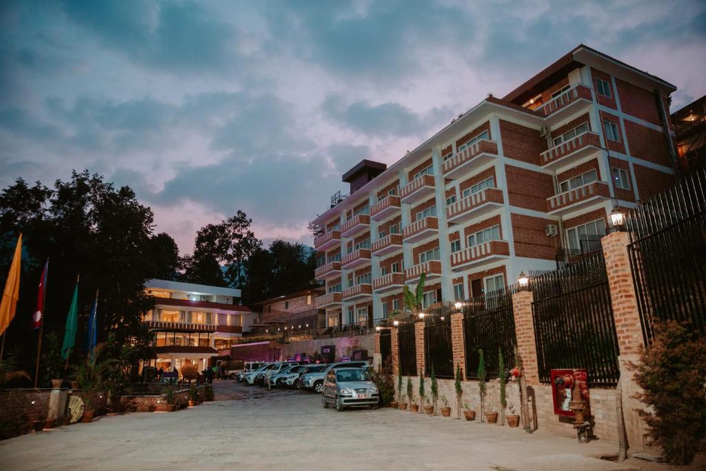 un gran edificio con coches estacionados frente a él en Hotel Monalisa Kathmandu Pvt. Ltd, en Katmandú