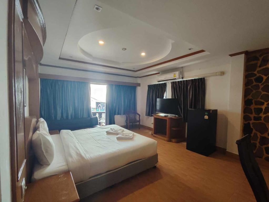 パトンビーチにあるRock Shore Patongのベッドとテレビが備わるホテルルームです。