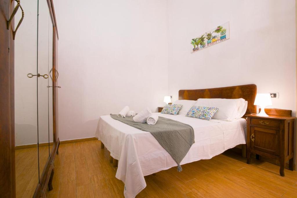 Schlafzimmer mit einem Bett mit weißer Bettwäsche und einem Tisch in der Unterkunft Casa Puccini Altstadt 5 Minuten | 8 km Meer in San Vito dei Normanni
