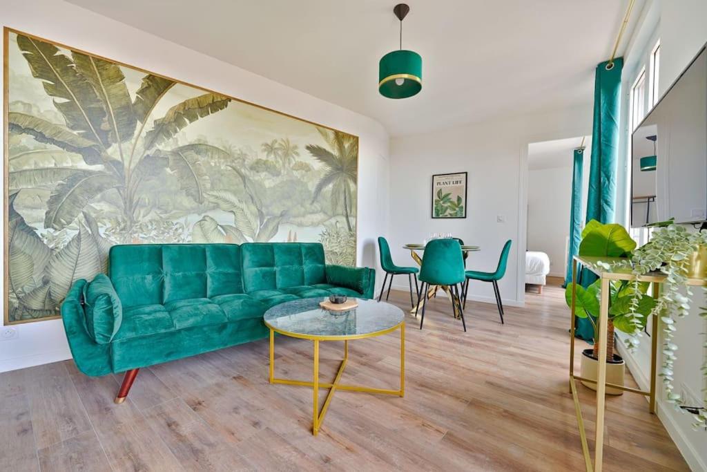 Una sala de estar con un sofá verde y una mesa. en Welcome to the green House, en Marly-le-Roi