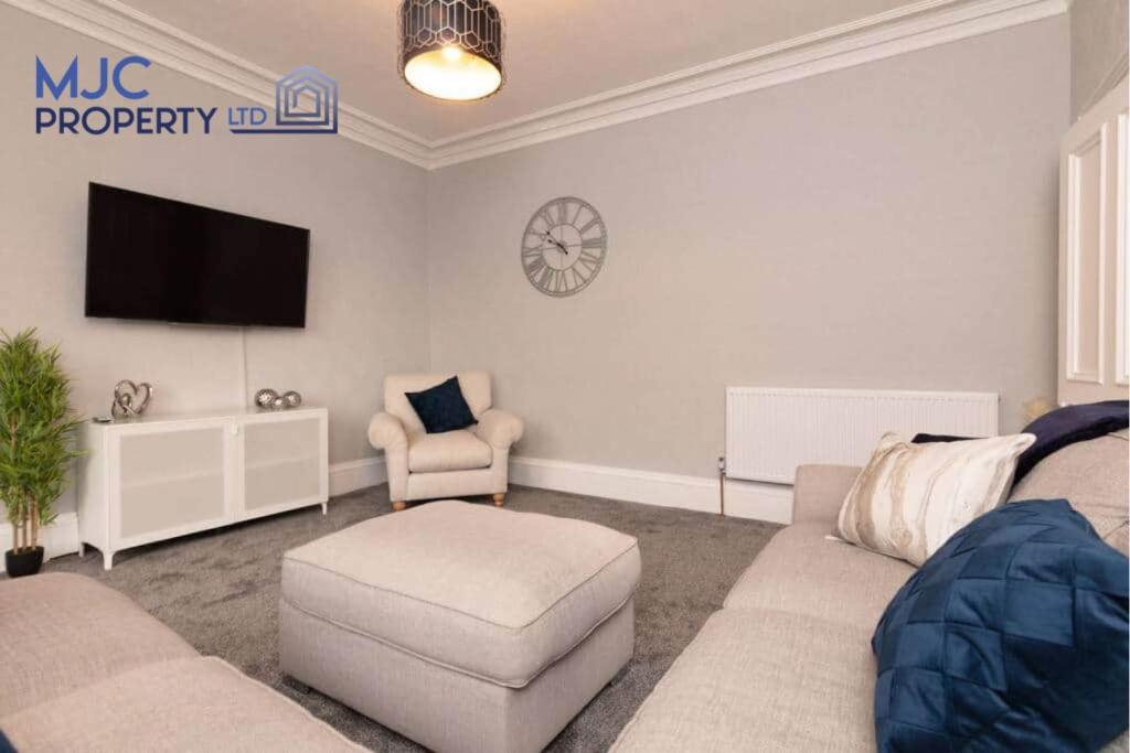 a living room with a couch and a tv at Turret Town House in Hawick