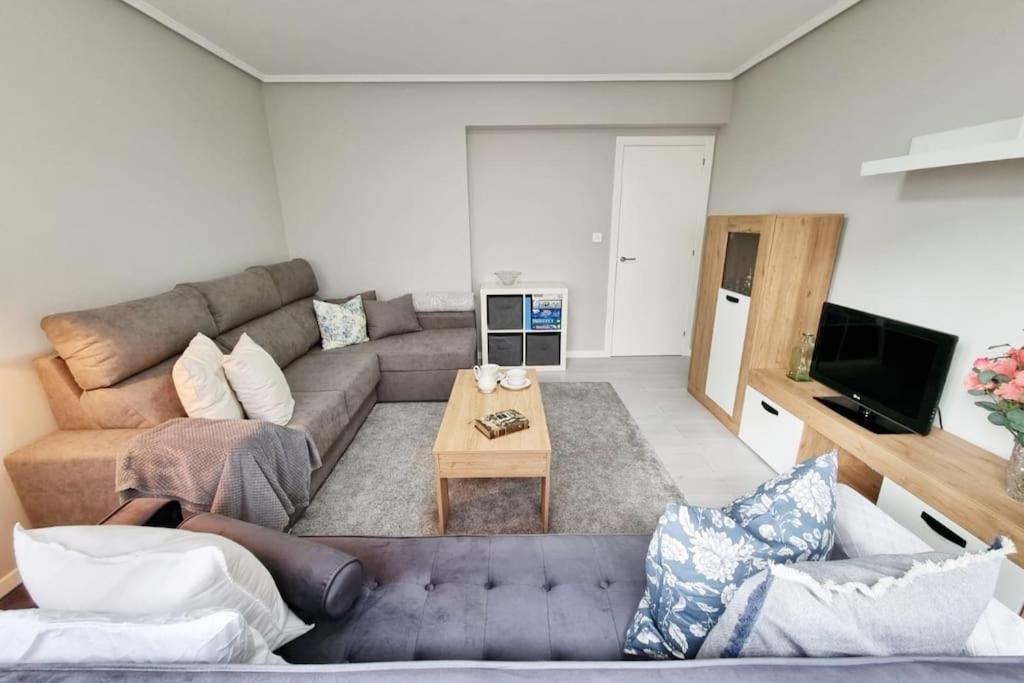 ein Wohnzimmer mit einem Sofa und einem Tisch in der Unterkunft VibesCoruña - Ángel 72 in A Coruña