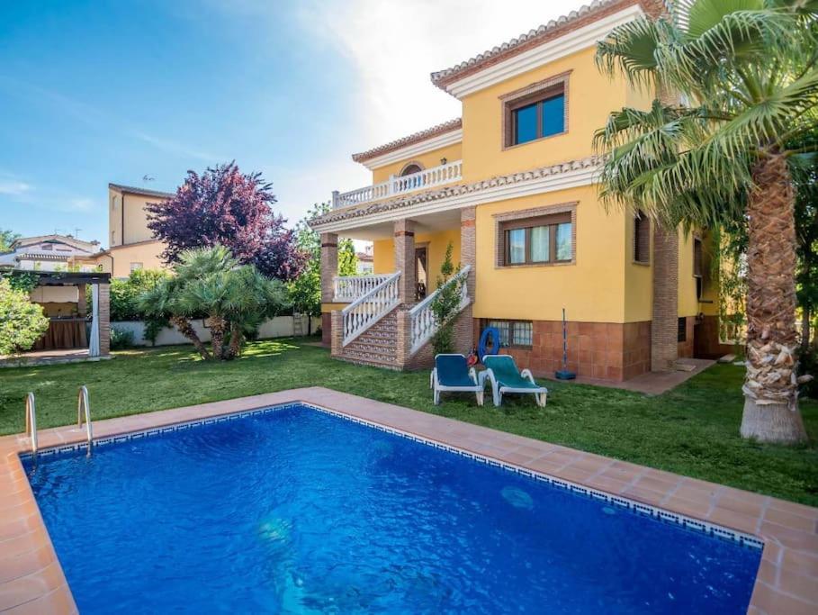 uma casa com piscina em frente a uma casa em Apto-en el Bajo de la casa-estilo rústico en Dílar em Dílar
