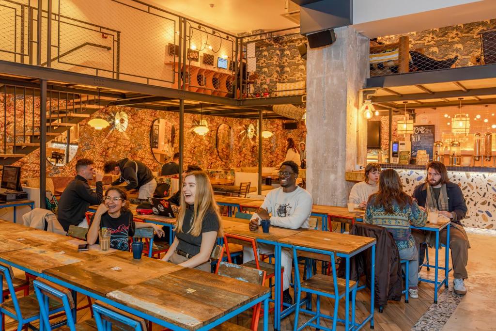 eine Gruppe von Personen, die in einem Restaurant an Tischen sitzen in der Unterkunft Villa Saint Exupery Beach Hostel in Nizza