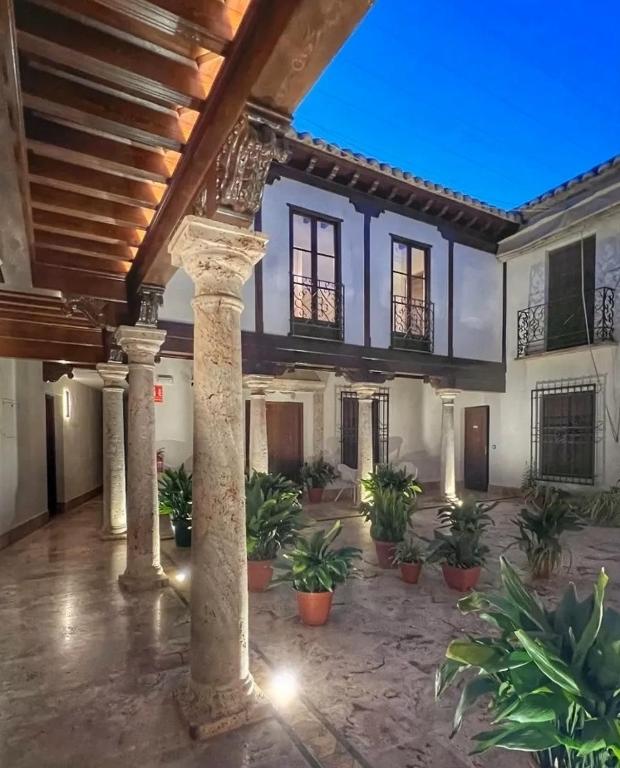 a large courtyard with columns and potted plants at Hotel QB Almagro Centro in Almagro