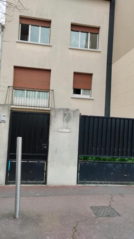 un bâtiment avec deux portes de garage devant lui dans l'établissement TONY House, à Bondy