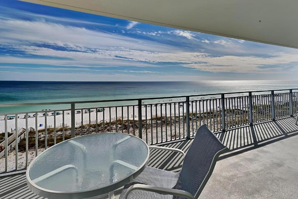 a balcony with a table and chairs and the beach at blu #606 Luxury 2 Bd Beachfront Condo in Fort Walton Beach