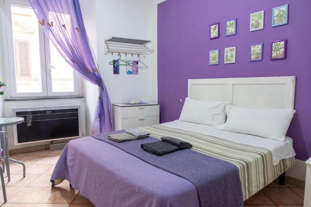 Dormitorio púrpura con cama con pared púrpura en Fruit Rooms en Roma