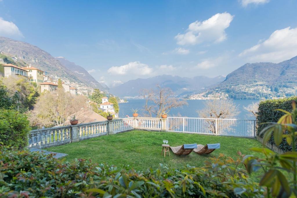 a balcony with a view of a lake and mountains at Besana 9 on the Lake - Private garden & parking by Rent All Como in Moltrasio