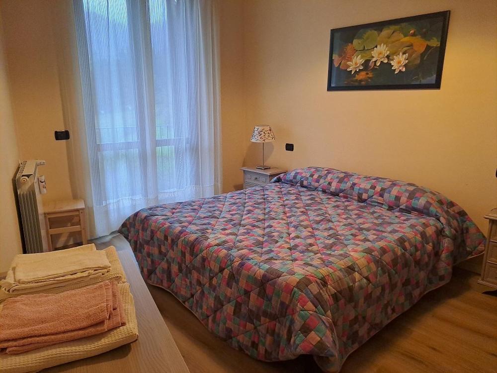 een slaapkamer met een bed met een dekbed en een raam bij The Green House in Troghi in Troghi