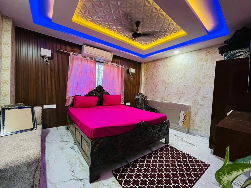 a room with a bed with pink sheets and a ceiling at PAGDANDI VILLA BY ALOHA in Udaipur