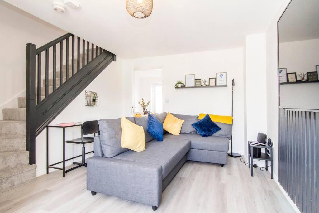 Captivating 3-Bedroom House with Netflix and Parking by HP Accommodation في Kibworth Harcourt: غرفة معيشة مع أريكة زرقاء والدرج