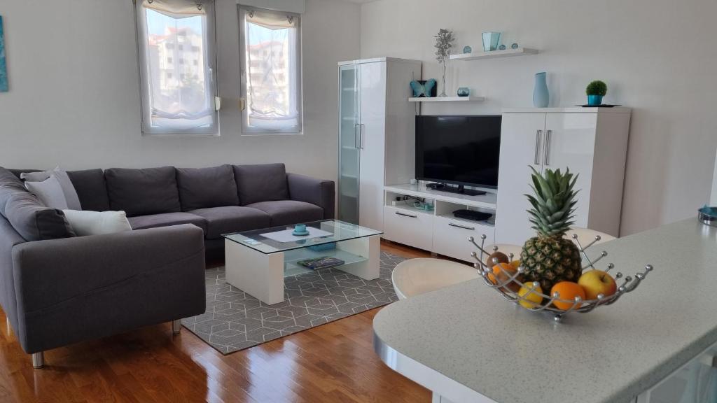 a living room with a couch and a table with a bowl of fruit at Apartment Domino in Split